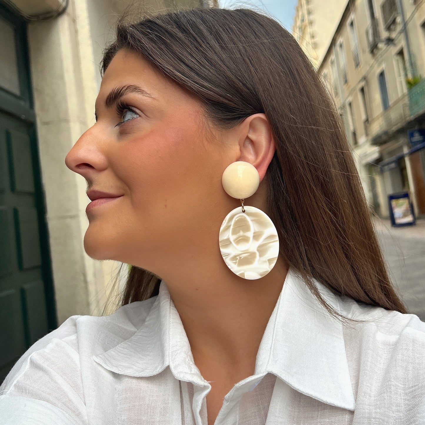 Boucles Mathilda Alba Francine Bramli Paris en résine ivoire nacrée avec pendentif ovale marbré crème.