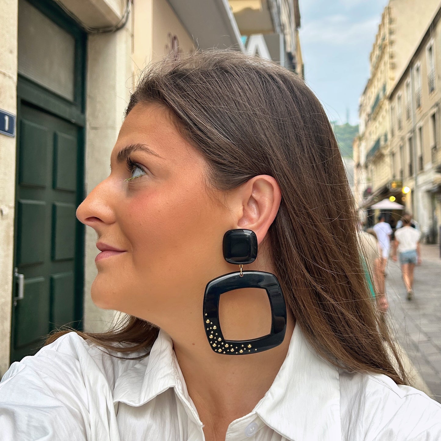 Boucles d'oreilles Reya Noir Clou Francine Bramli en résine noire avec grand carré ajouré et clous dorés