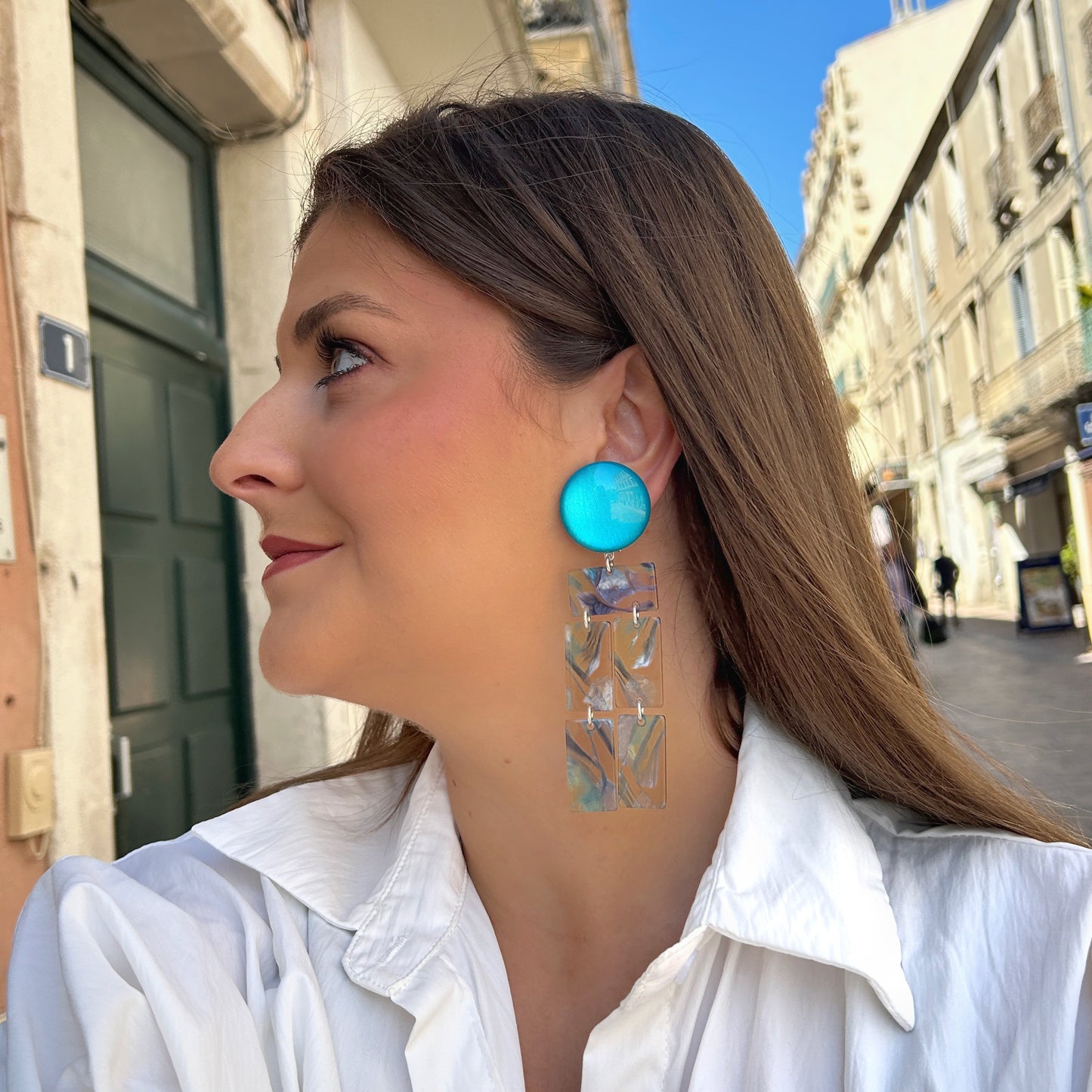 Boucles Romane Francine Bramli Paris en résine marbrée bleu turquoise et nacrée avec design graphique articulé.