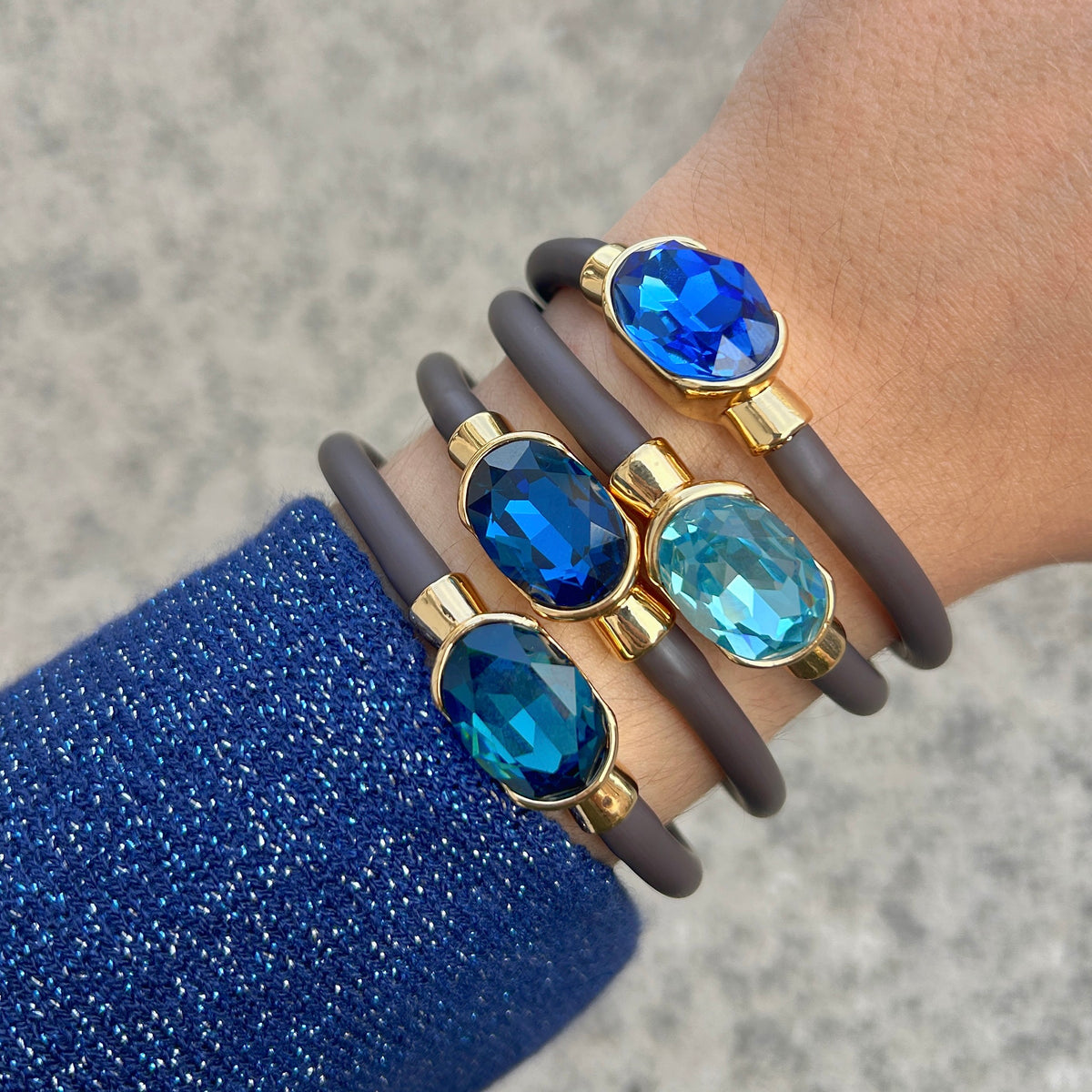 Bracelet Gala Bleu Pétrole avec cristal ovale facetté bleu profond, monture dorée et bracelet marron