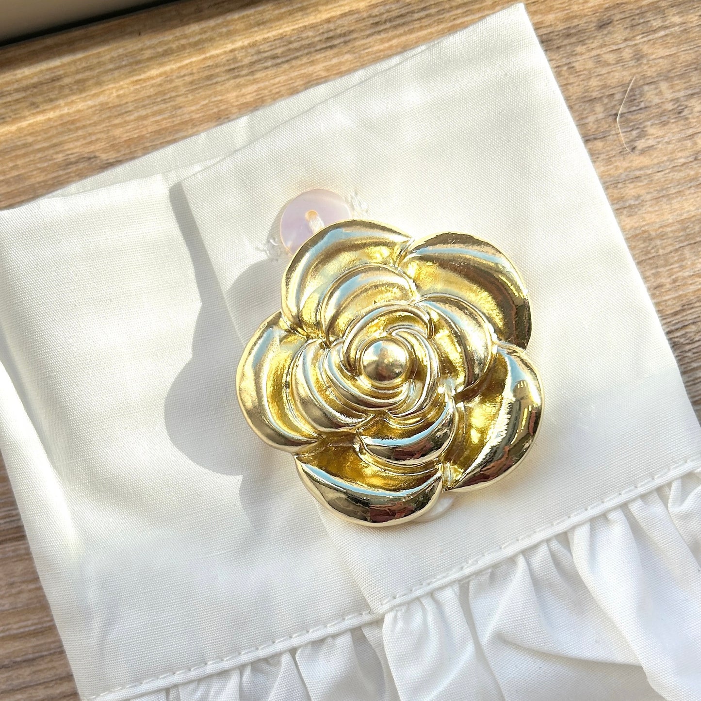 Détail broche aimantée fleur dorée finition brillante