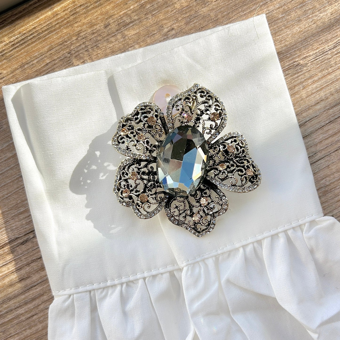 Détail broche fleur baroque strass et pierre facettée