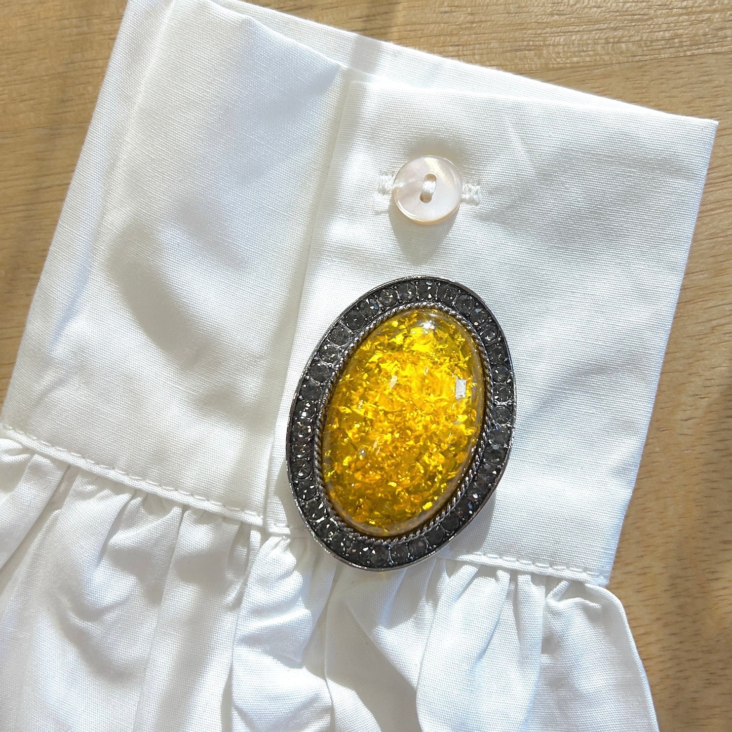 Détail broche cabochon jaune strass