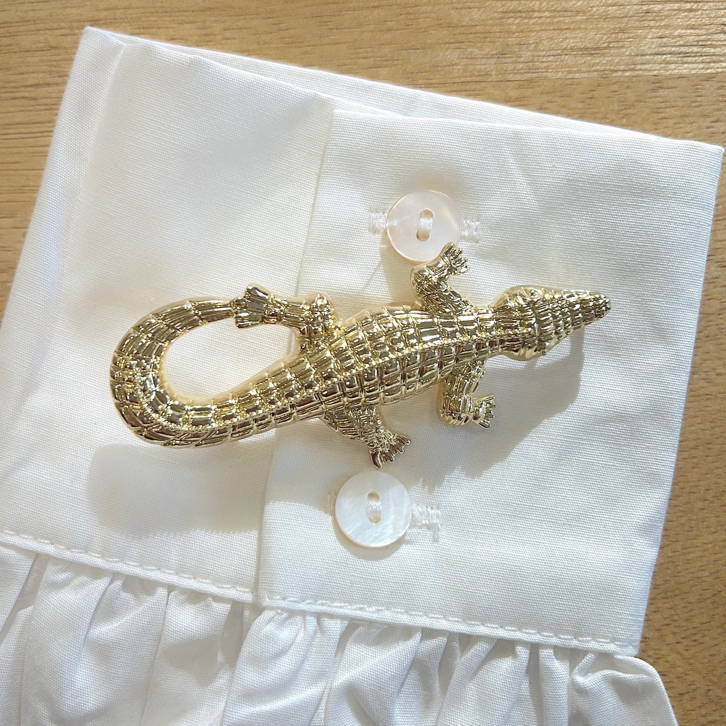 Détail broche crocodile doré relief