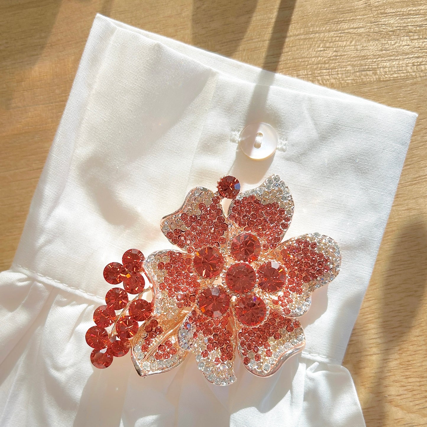 Détail de la broche fleur corail strass et monture dorée