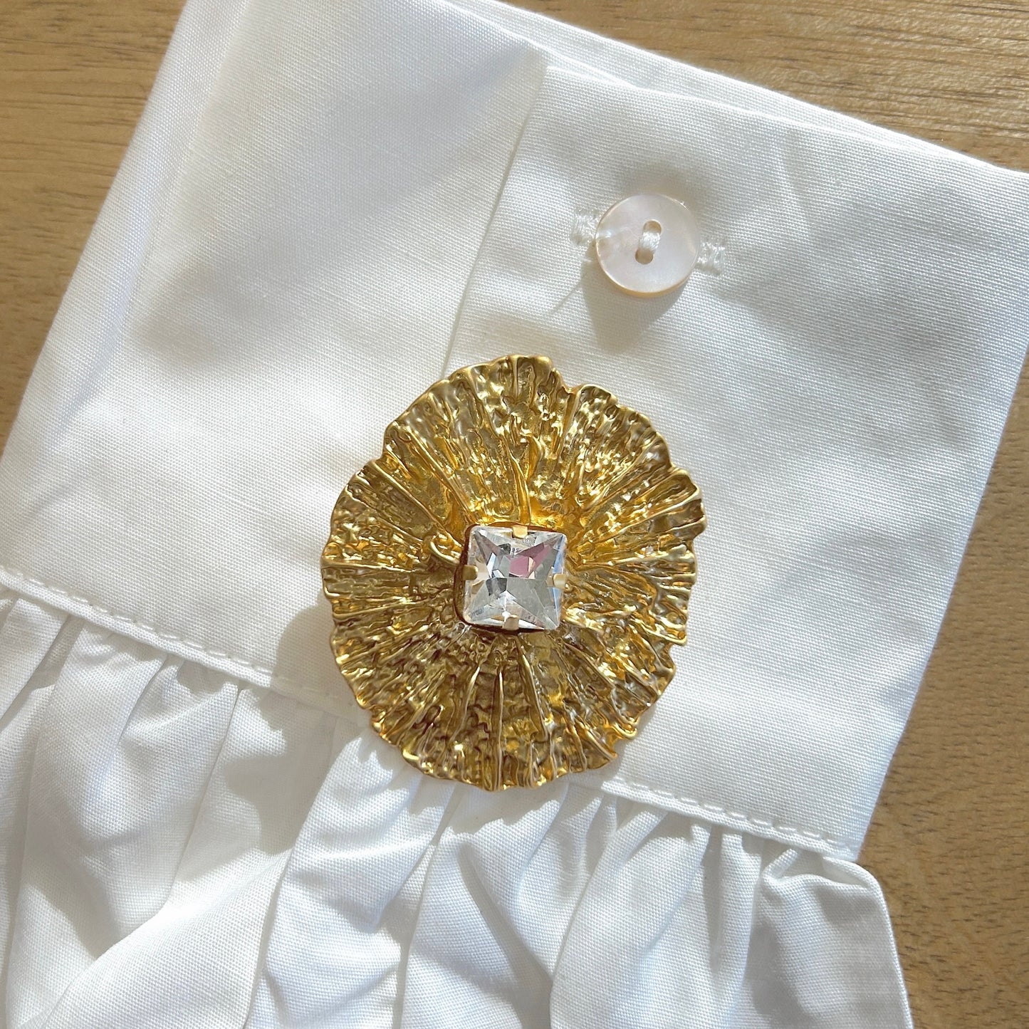 Détail broche martelée dorée strass