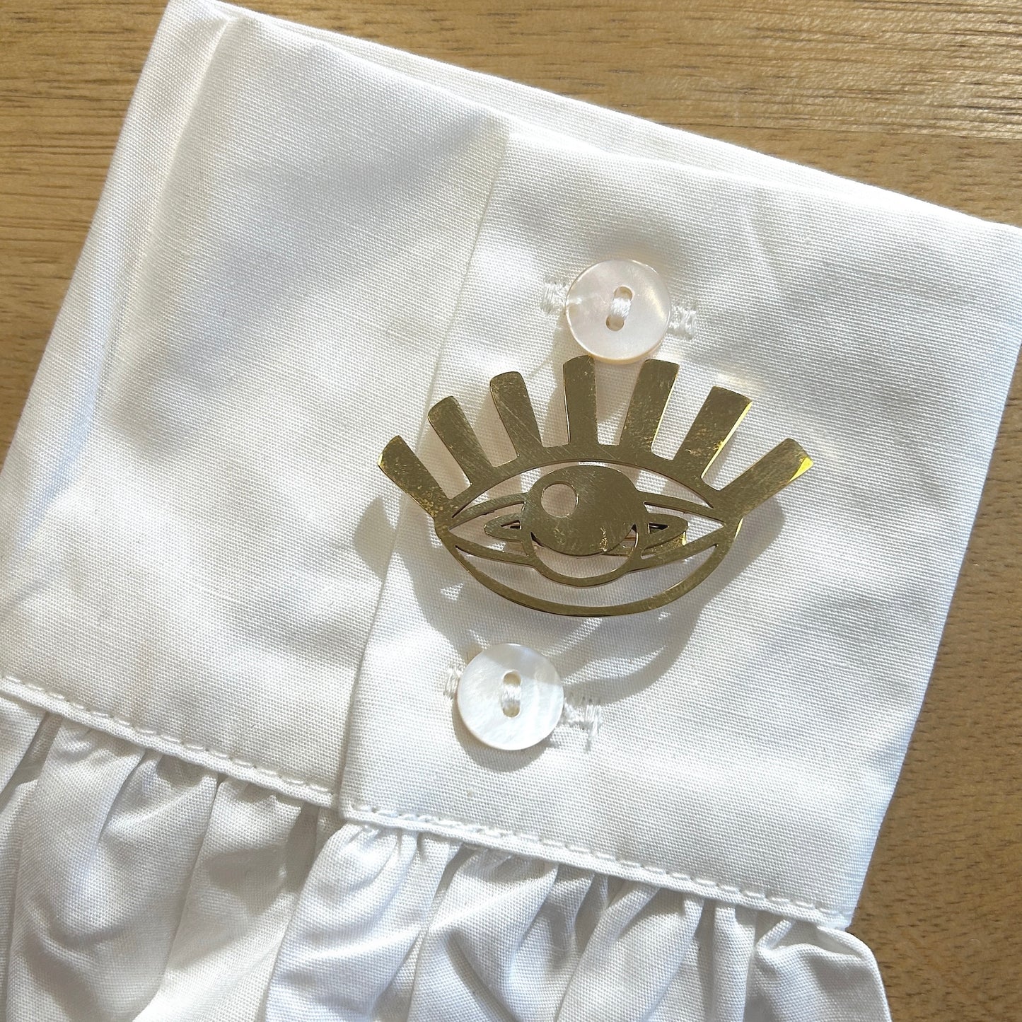 Détail broche œil doré finition métallique