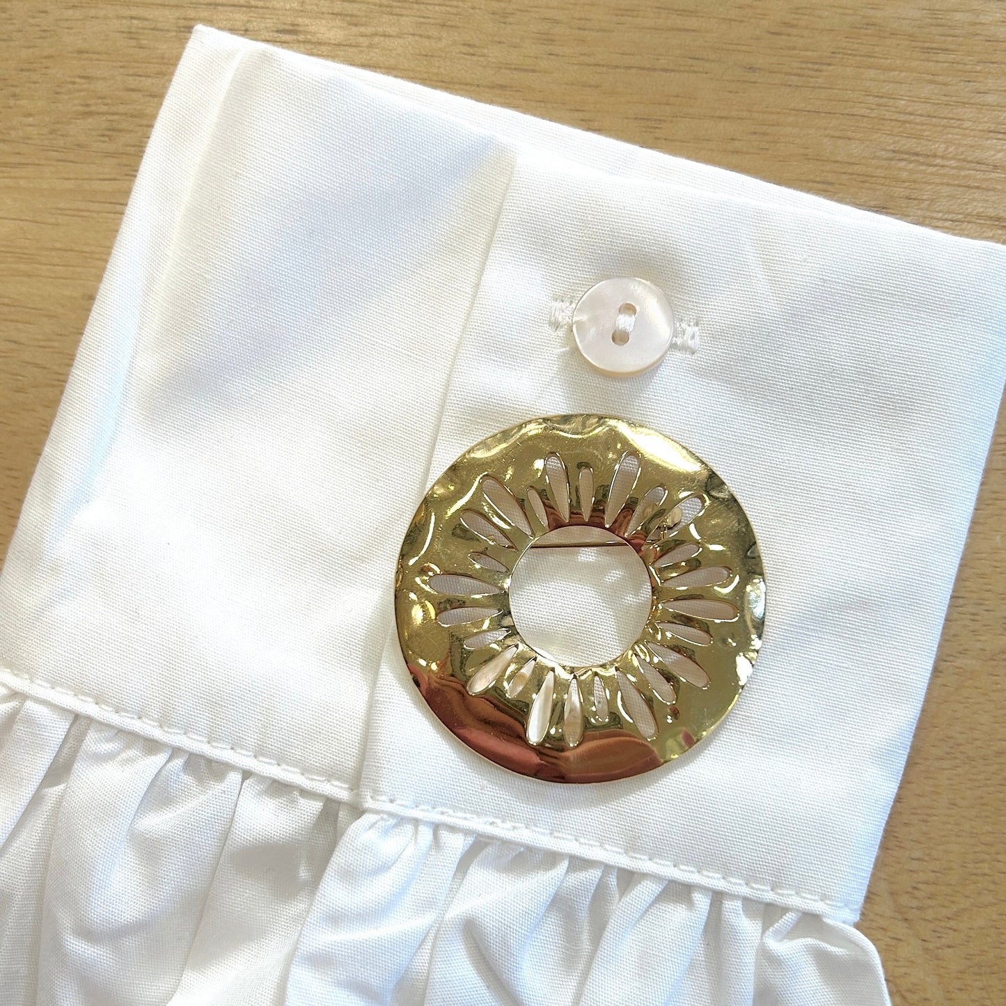 Détail broche soleil martelé doré