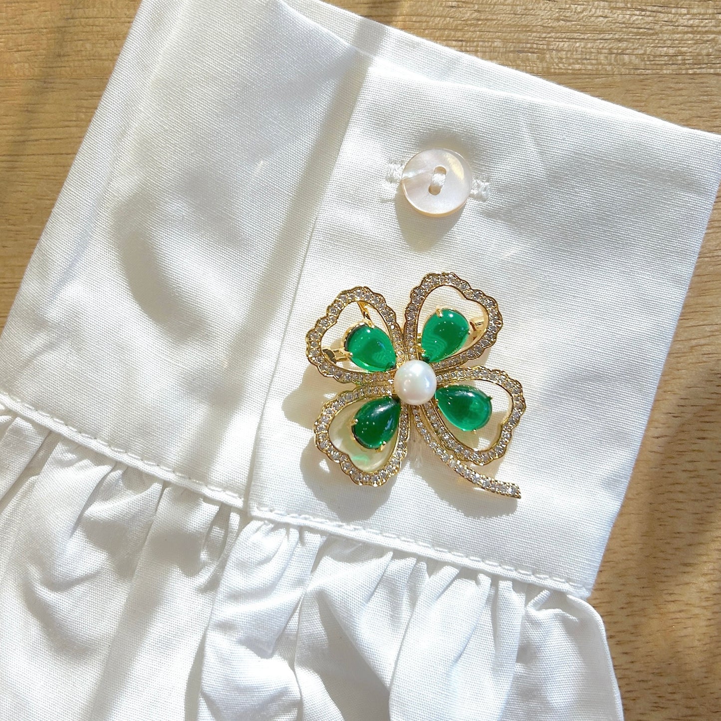 Détail broche trèfle vert strass et perle