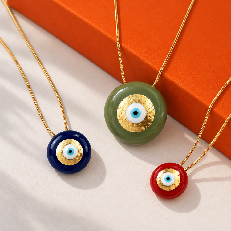 Collection Sofia Papalexiou chez Divinity Sète, colliers Evil Eye aux pendentifs ronds colorés avec œil grec protecteur bleu et détails dorés.