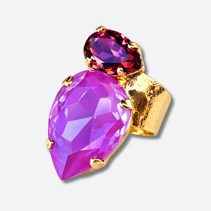 Bague Calypso Mûre Crézus avec grand cristal rose fuchsia en forme de goutte, petit cristal facetté couleur mûre et grenat, sertissage doré à griffes et anneau large martelé.