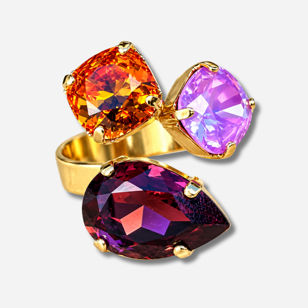 Bague Dalia Figue Crézus avec trois cristaux facettés couleur figue, orange et rose lilas, sertis sur une monture dorée asymétrique – Divinity Sète.