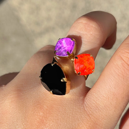 Bague Dalia Fluo Crézus avec trois cristaux facettés violet, orange fluo et noir, sertis sur une monture dorée asymétrique – Divinity Sète.