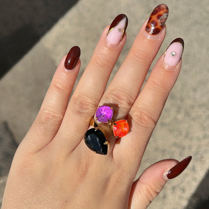 Bague Dalia Fluo Crézus avec trois cristaux facettés violet, orange fluo et noir, sertis sur une monture dorée asymétrique – Divinity Sète.