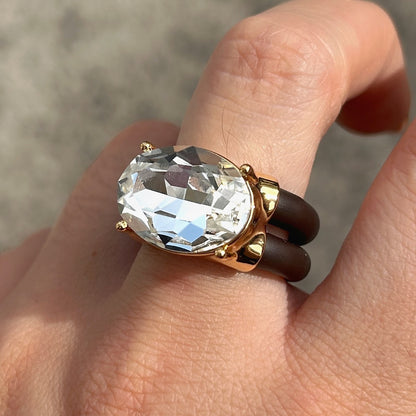 Bague Diva Blanc avec grand cristal ovale facetté transparent, monture dorée et double anneau marron