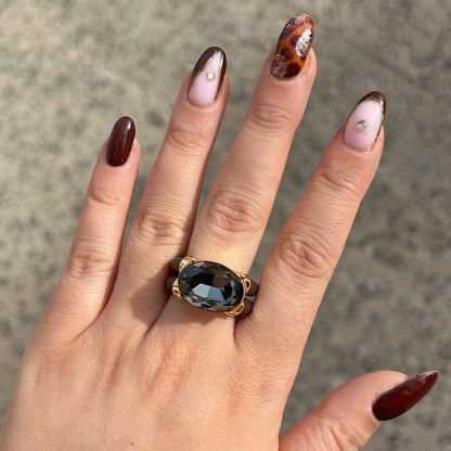 Bague Diva Gris avec grand cristal ovale facetté gris fumé, monture dorée et double anneau marron