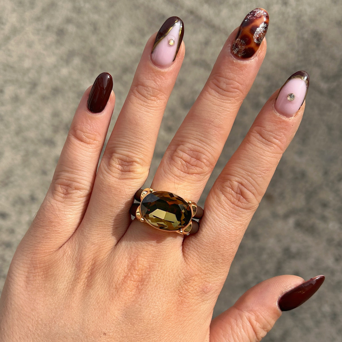 Bague Diva Kaki avec grand cristal ovale facetté, monture dorée et double anneau marron