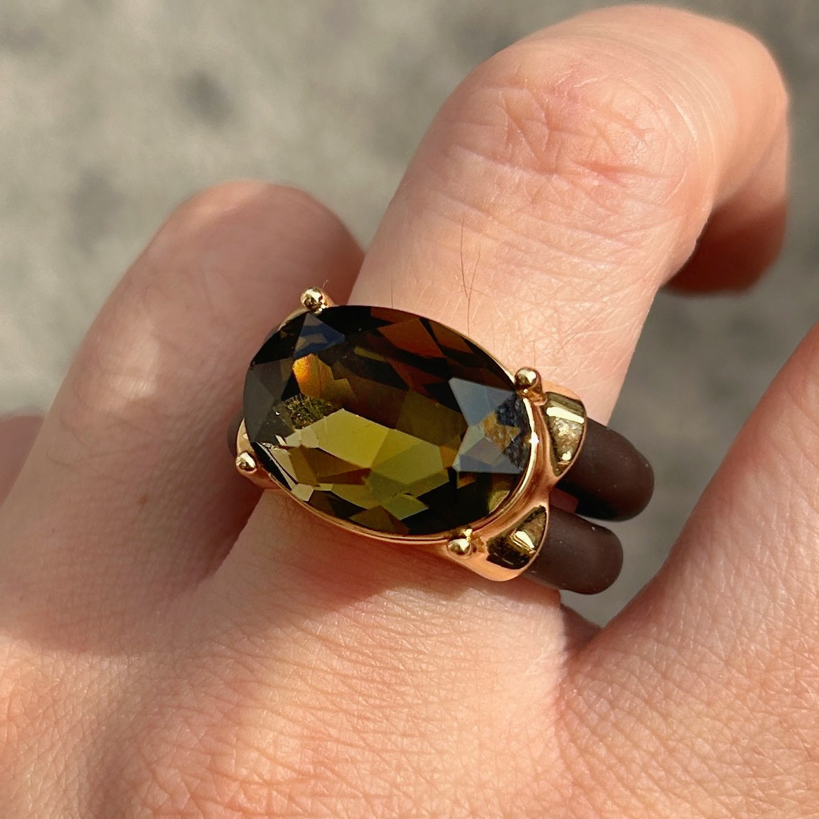 Bague Diva Kaki avec grand cristal ovale facetté, monture dorée et double anneau marron