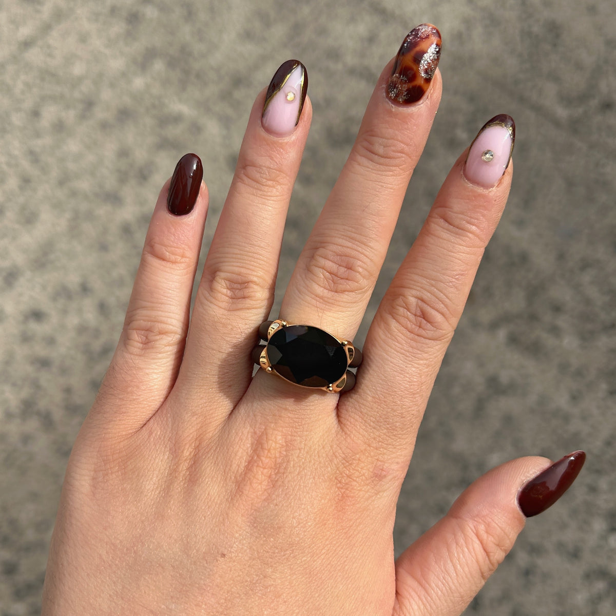 Bague Diva Noir avec grand cristal ovale noir facetté, monture dorée et double anneau marron