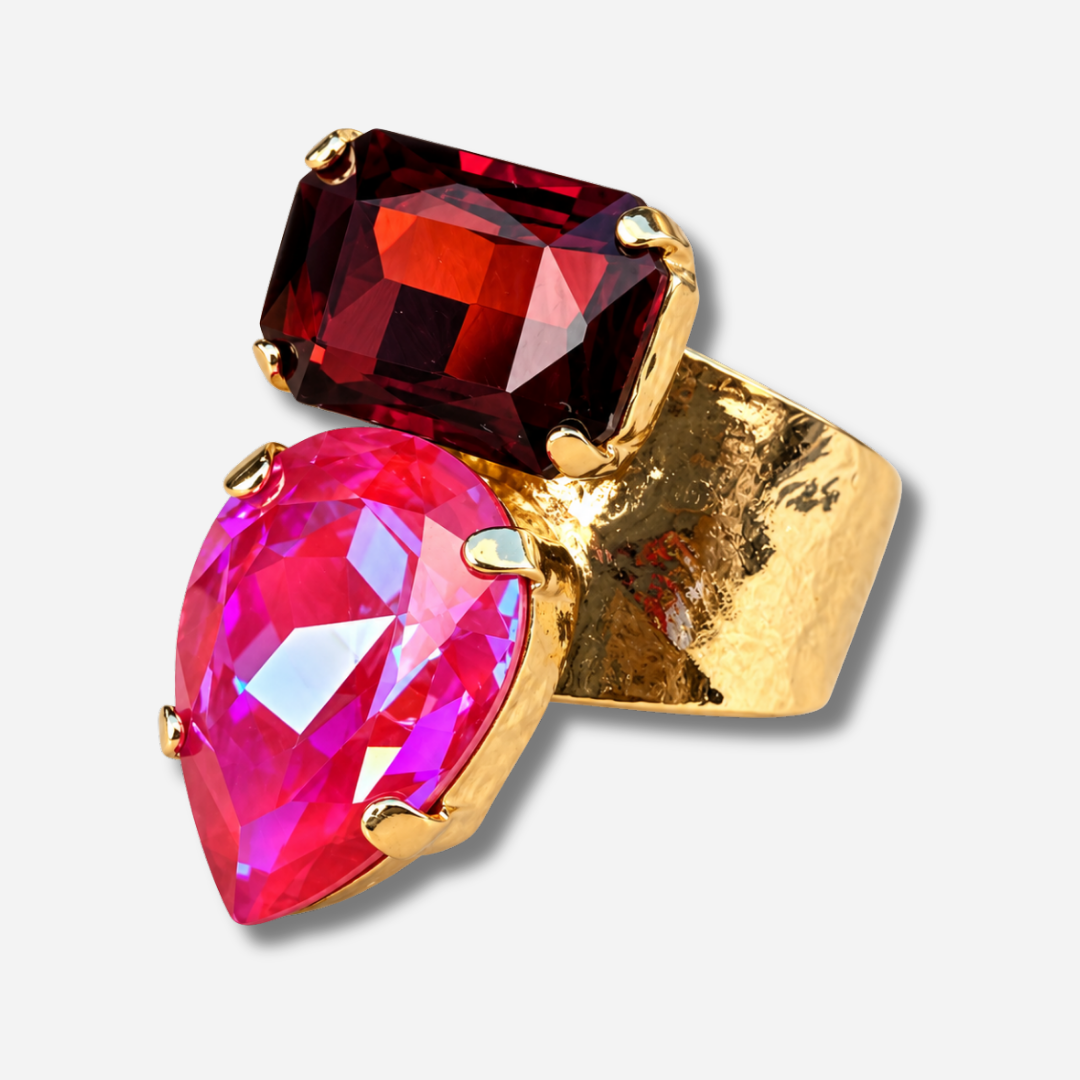 Bague Lyra Cerise Crézus avec cristal rose cerise en forme de goutte et cristal rectangulaire rouge rubis, sertis sur une large monture dorée texturée – Divinity Sète.