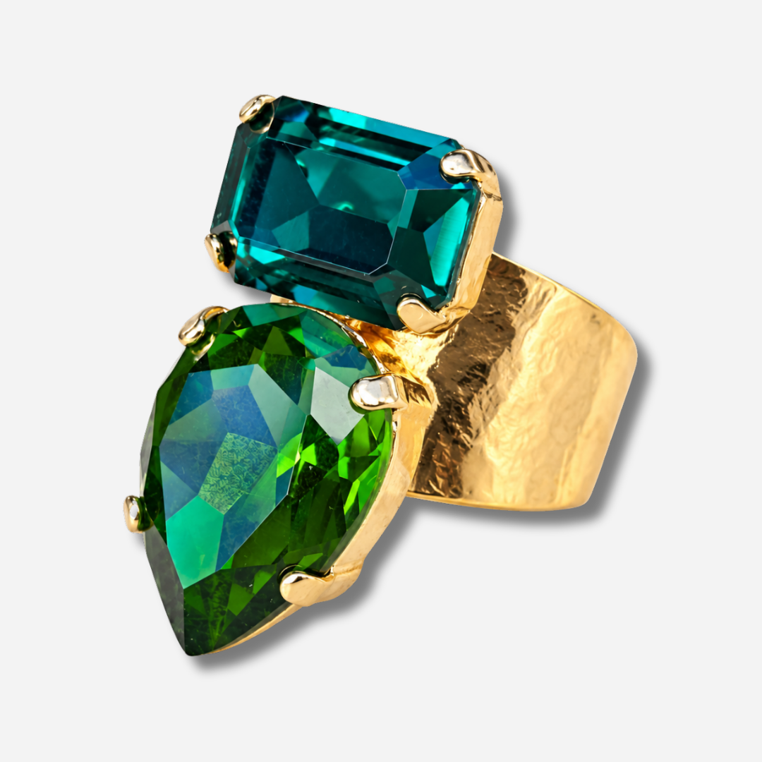 Bague Lyra Émeraude Crézus avec deux cristaux facettés vert émeraude et vert profond, en forme de goutte et de rectangle, sur une large monture dorée texturée – Divinity Sète.