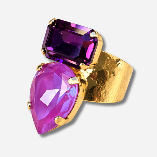 Bague Lyra Mûre Crézus avec cristal rose orchidée en forme de goutte et cristal rectangulaire violet mûre, sertis sur une large monture dorée texturée – Divinity Sète.
