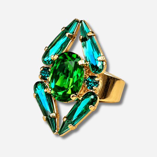 Bague Mira Émeraude Crézus avec grand cristal ovale vert émeraude, quatre cristaux allongés turquoise, petits cristaux vert canard et monture dorée à anneau large.