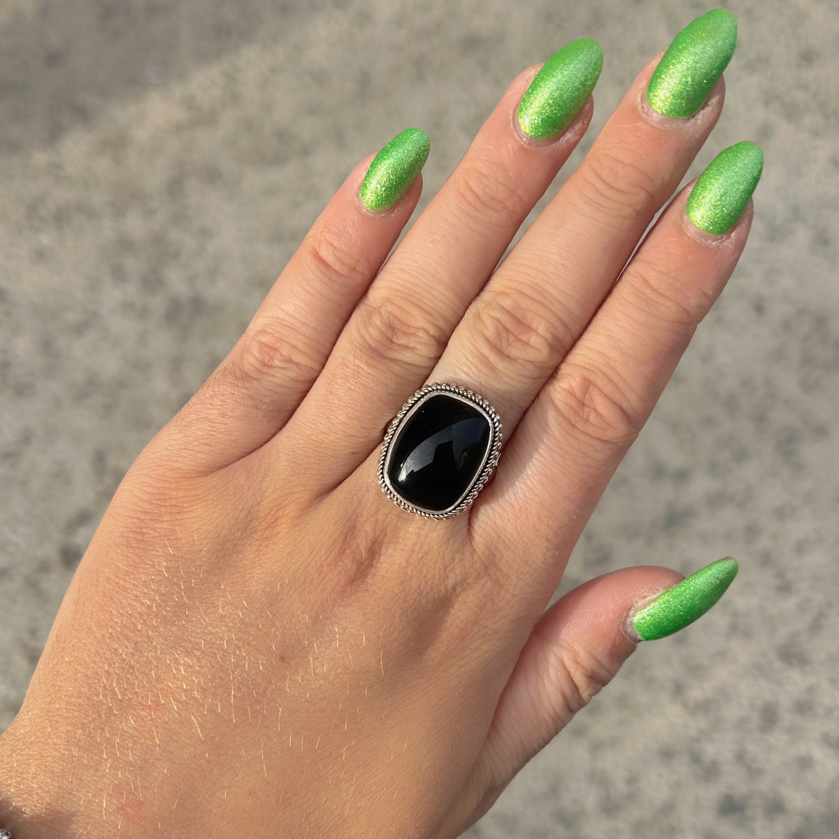 Bague Onyx Noir Rectangle XS en argent 925 avec contour tressé portée à la main
