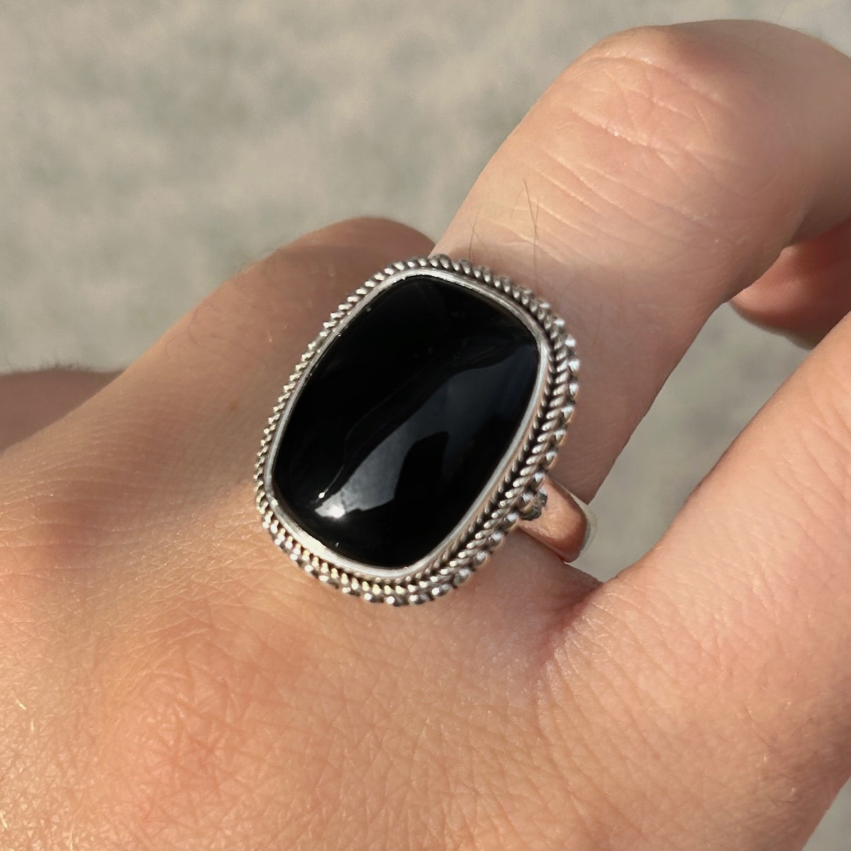 Bague Onyx Noir Rectangle XS en argent 925 avec contour tressé portée à la main
