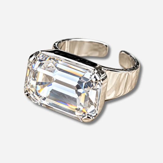 Bague Pinky Ring Silver Crézus avec grand cristal transparent rectangulaire taille émeraude, monture argentée à quatre griffes et anneau large ouvert ajustable.