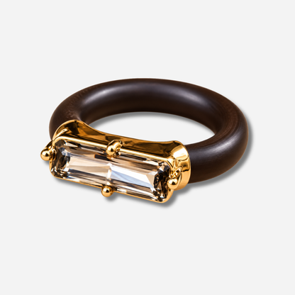 : Bague Riva Gris avec cristal rectangulaire facetté gris fumé, monture dorée et anneau marron