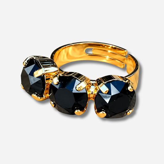 Bague Trio Black Crézus dorée ornée de trois cristaux noirs ronds facettés, sertis de griffes dorées et disposés côte à côte.