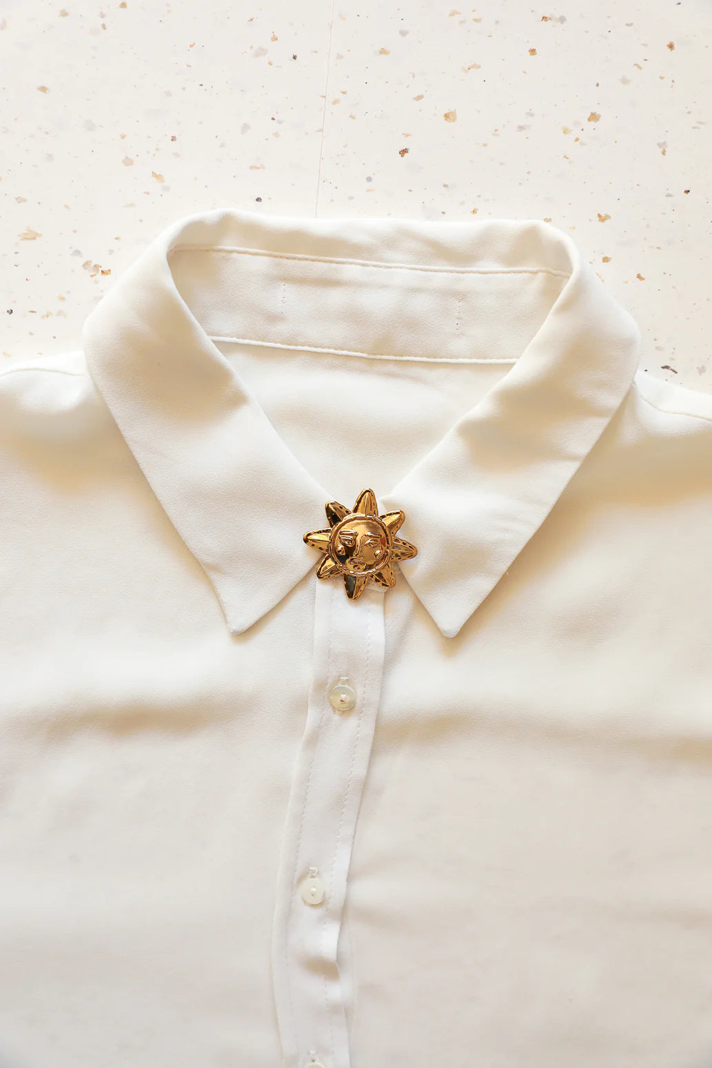 Bijou de bouton Annee porté sur chemise blanche Divinity Sète