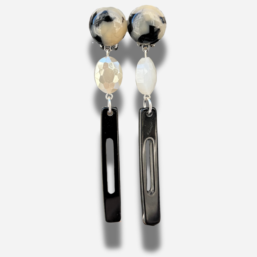 Boucles Bâton Écaille Noir et Blanc Francine Bramli Paris avec résine marbrée noire et ivoire, perle facettée blanche et pendentif graphique noir.