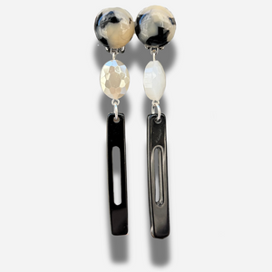 Boucles Bâton Écaille Noir et Blanc Francine Bramli Paris avec résine marbrée noire et ivoire, perle facettée blanche et pendentif graphique noir.