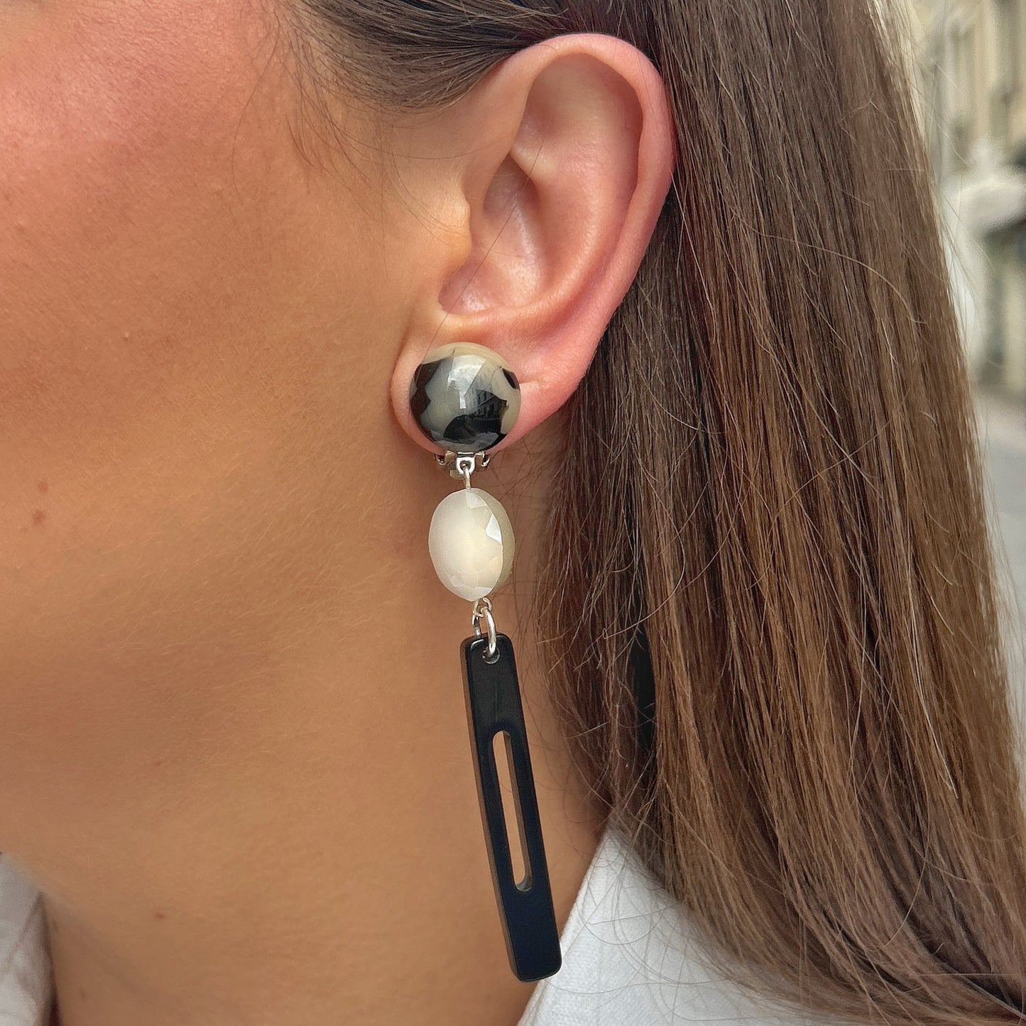 Boucles Bâton Écaille Noir et Blanc Francine Bramli Paris avec résine marbrée noire et ivoire, perle facettée blanche et pendentif graphique noir.