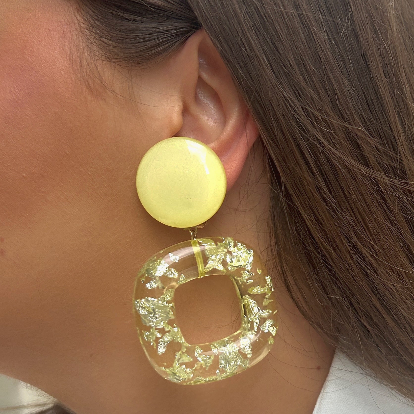 Boucles Caïcos Jaune Francine Bramli Paris en résine jaune translucide avec éclats métallisés dorés et design géométrique moderne.