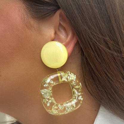 Boucles Caïcos Jaune Francine Bramli Paris en résine jaune translucide avec éclats métallisés dorés et design géométrique moderne.