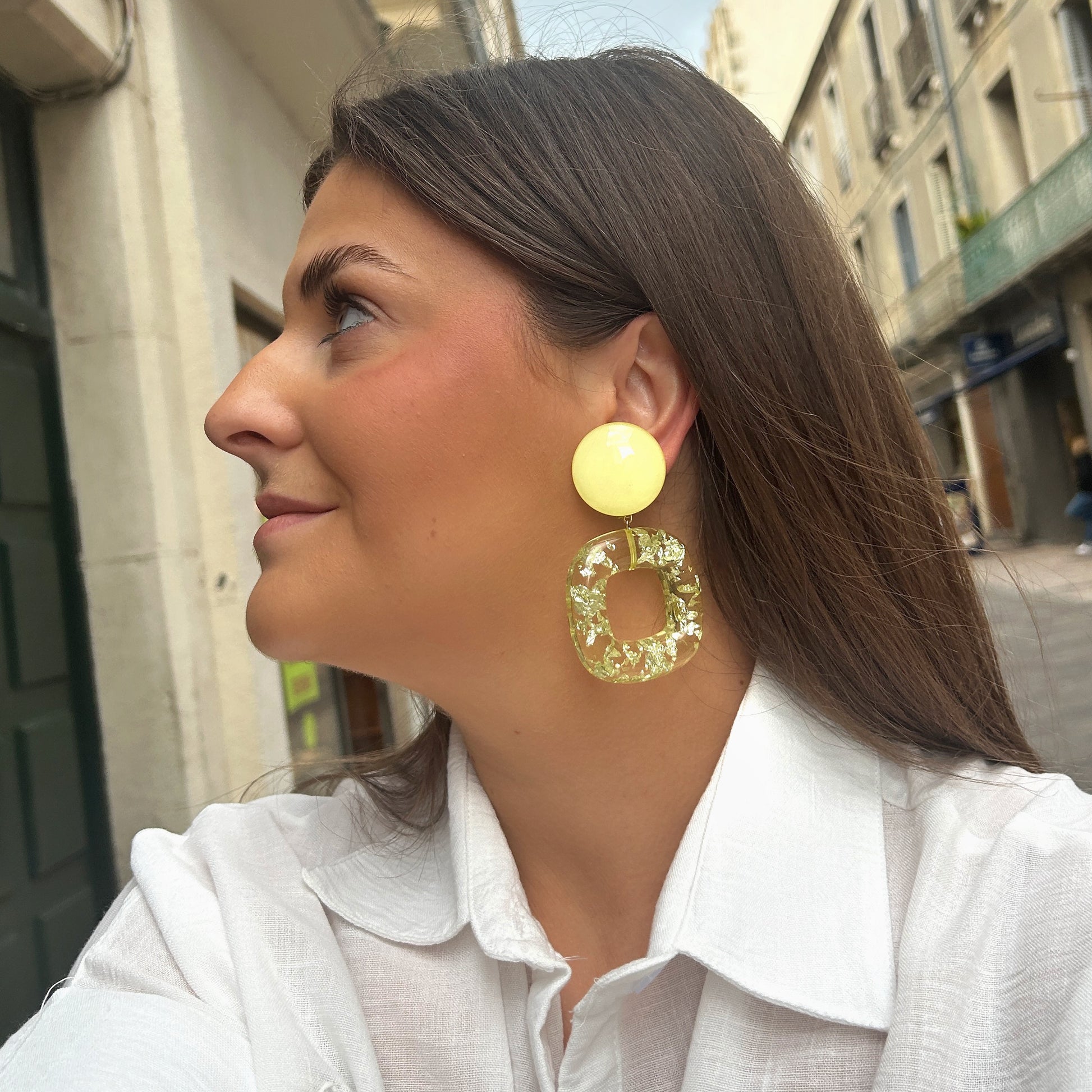 Boucles Caïcos Jaune Francine Bramli Paris en résine jaune translucide avec éclats métallisés dorés et design géométrique moderne.