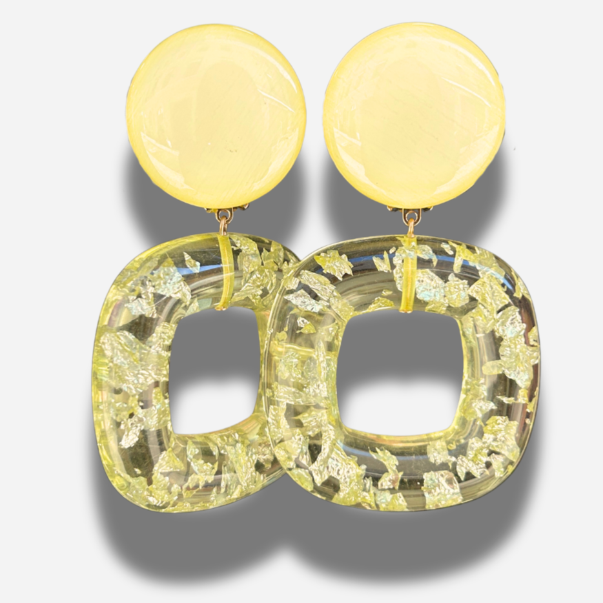Boucles Caïcos Jaune Francine Bramli Paris en résine jaune translucide avec éclats métallisés dorés et design géométrique moderne.