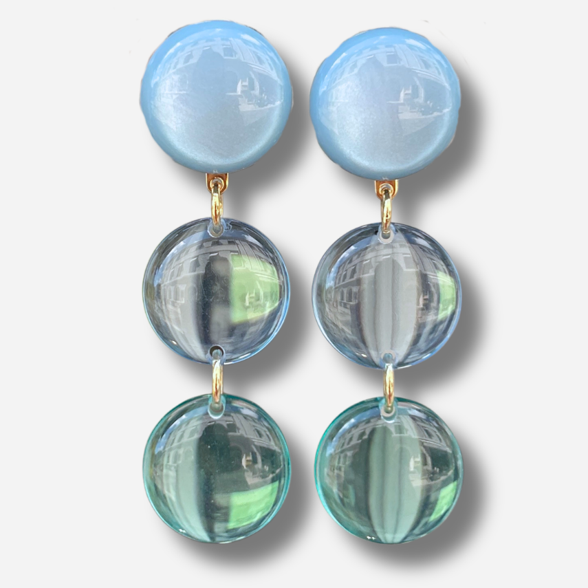Boucles d'oreilles Cristallines Bleu Ciel Francine Bramli Paris en résine bleu pastel translucide composées de trois pastilles lumineuses.