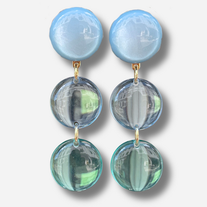 Boucles d'oreilles Cristallines Bleu Ciel Francine Bramli Paris en résine bleu pastel translucide composées de trois pastilles lumineuses.