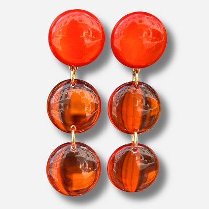 Boucles d'oreilles Cristallines Rouge Francine Bramli Paris en résine rouge translucide composées de trois pastilles lumineuses.