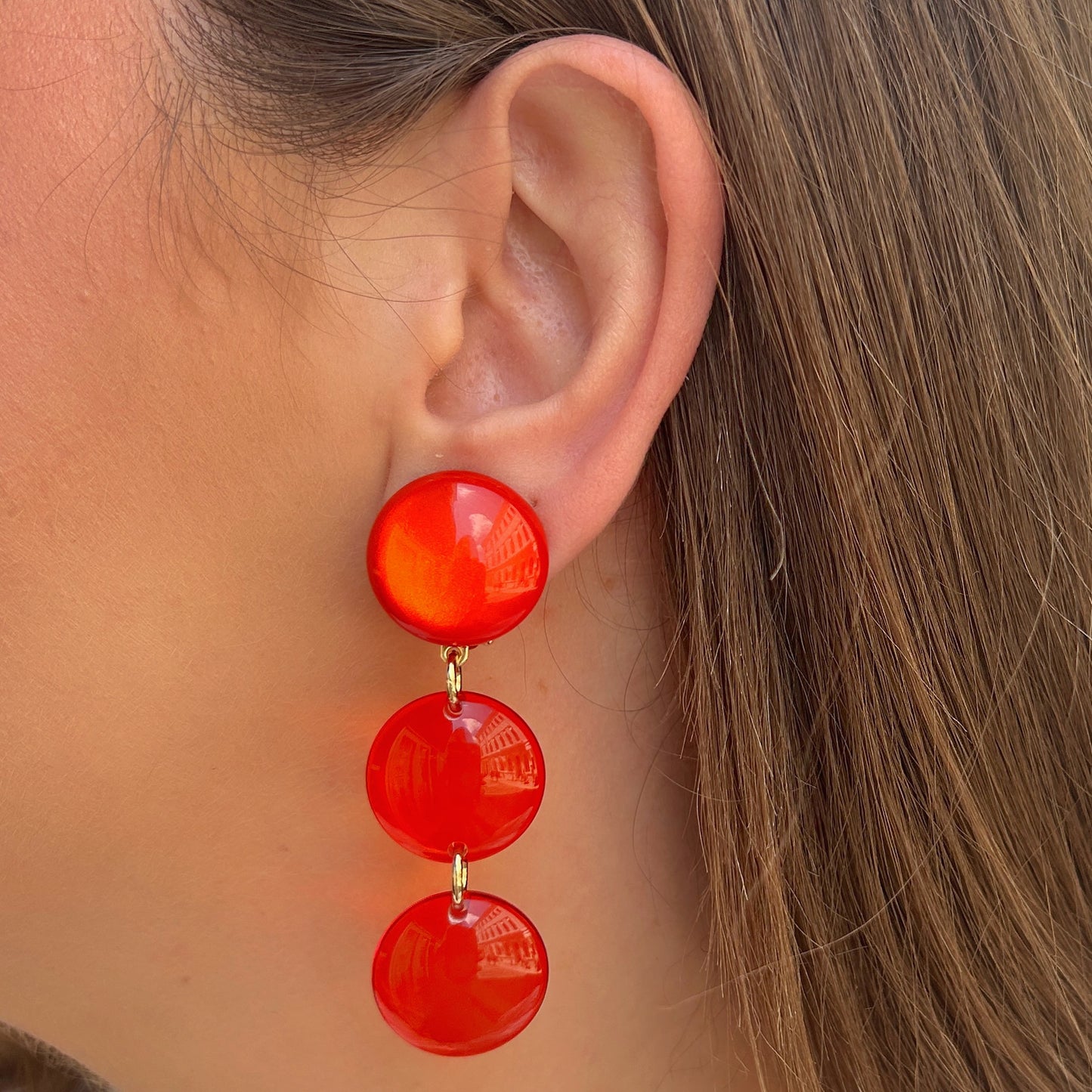 Boucles d'oreilles Cristallines Rouge Francine Bramli Paris en résine rouge translucide composées de trois pastilles lumineuses.
