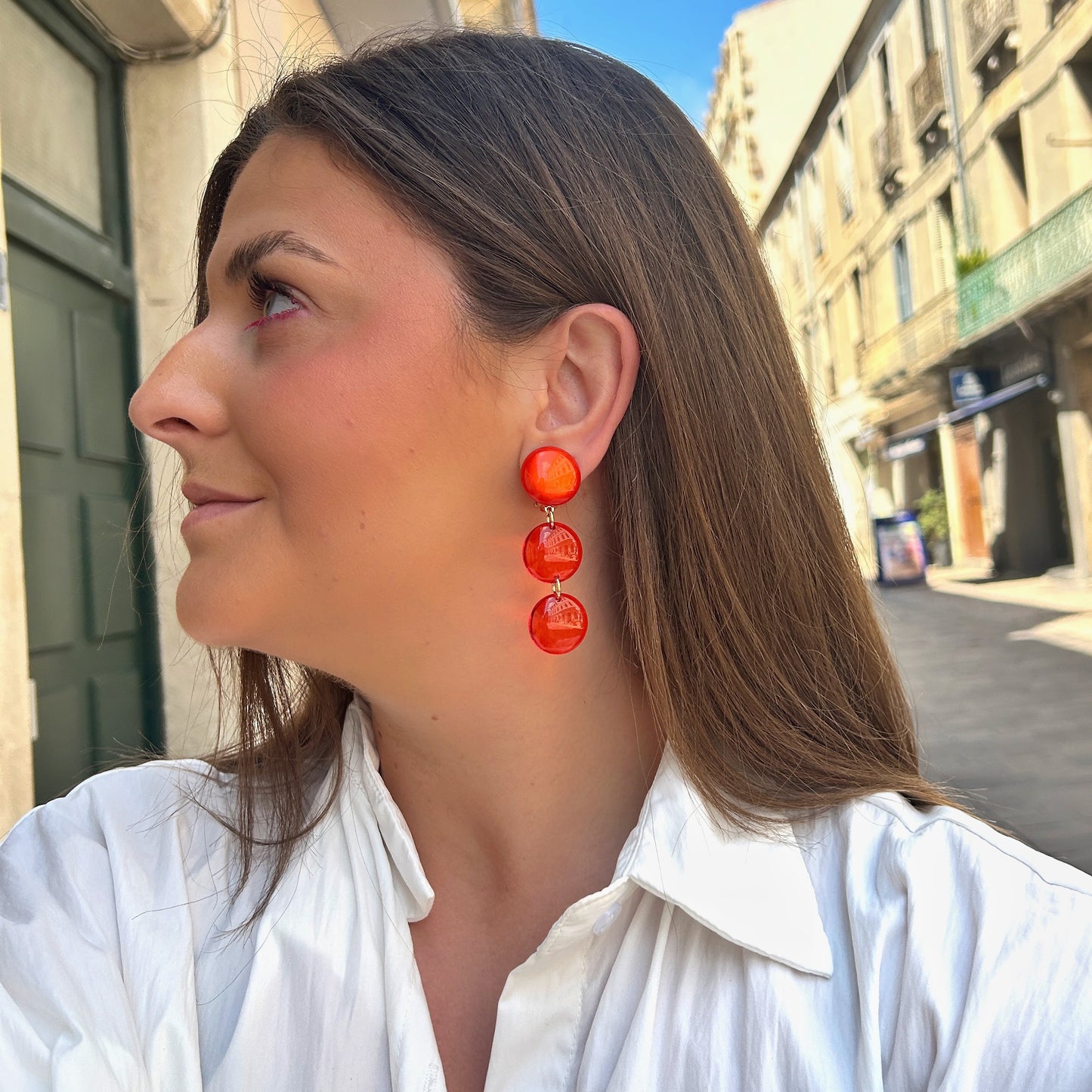 Boucles d'oreilles Cristallines Rouge Francine Bramli Paris en résine rouge translucide composées de trois pastilles lumineuses.