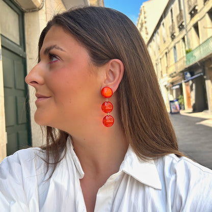 Boucles d'oreilles Cristallines Rouge Francine Bramli Paris en résine rouge translucide composées de trois pastilles lumineuses.