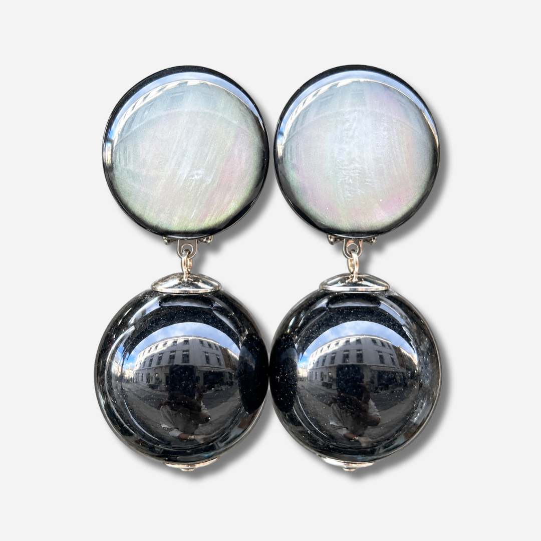 Boucles d’oreilles Disco Noir à clips Francine Bramli Paris, cabochons ronds nacrés gris irisé et grandes perles sphériques noires brillantes.