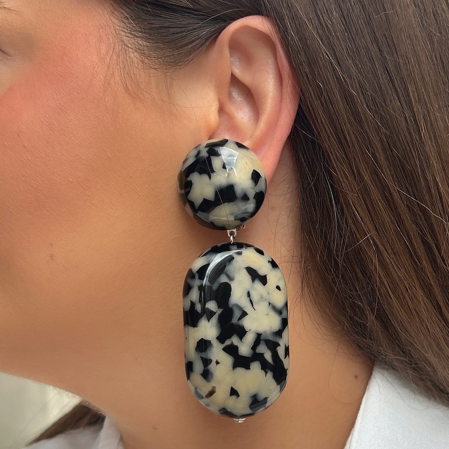 Boucles Galet Écaille Noir et Blanc Francine Bramli Paris en résine marbrée noire et ivoire avec design graphique élégant et contemporain.
