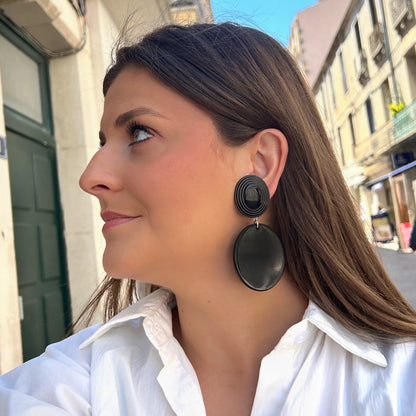 Boucles Hazel Noir Francine Bramli Paris avec cabochon ovale texturé noir et pendentif rond noir brillant portées sur mannequin chez Divinity Sète.