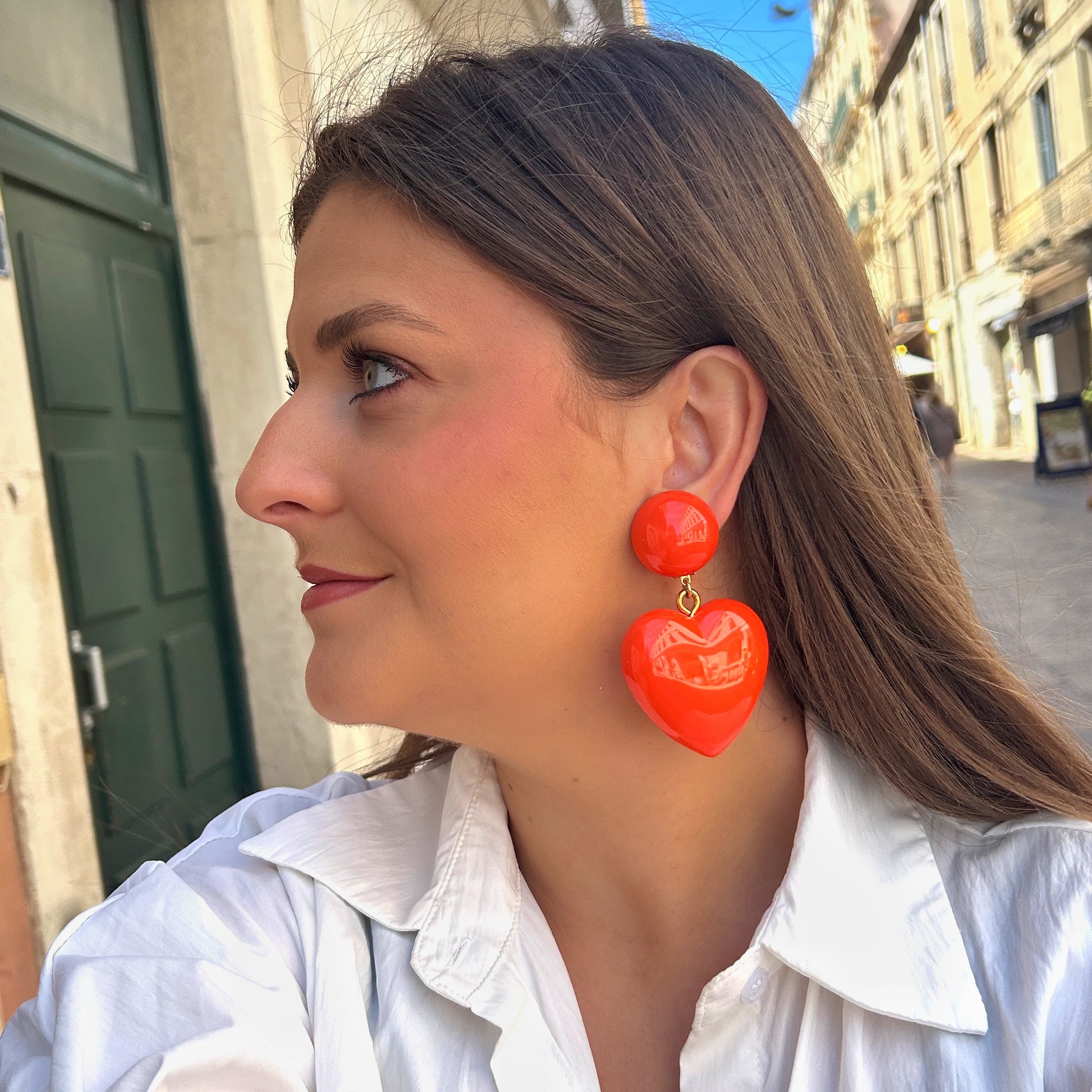 Boucles Heart Orange Francine Bramli Paris avec pendentif cœur oversize orange vif en résine brillante portées – boucles colorées tendance femme chez Divinity Sète